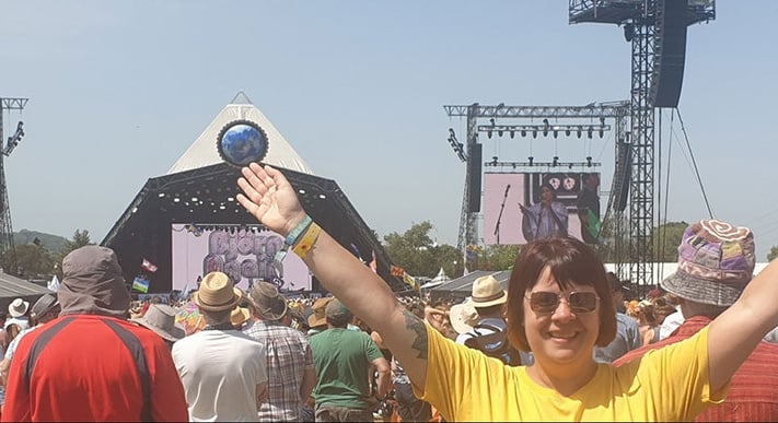 Kerry Cottam, Senior Designer in front of Glastonbury Pyramid stage